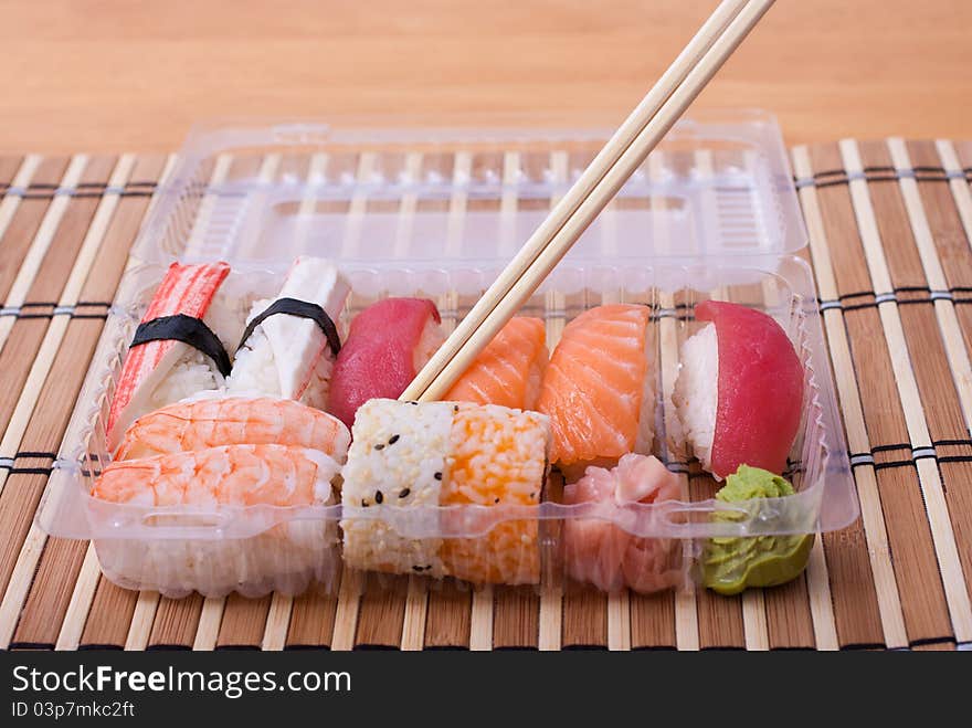 Take away sushi set with chopsticks. Selective focus. Take away sushi set with chopsticks. Selective focus.