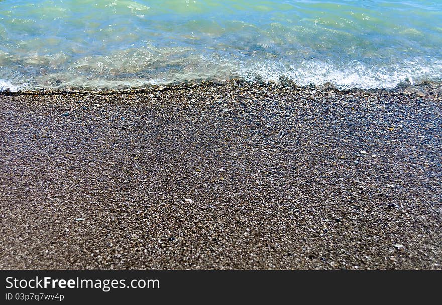 Sea surf on the rocks falling pebble beach. Sea surf on the rocks falling pebble beach