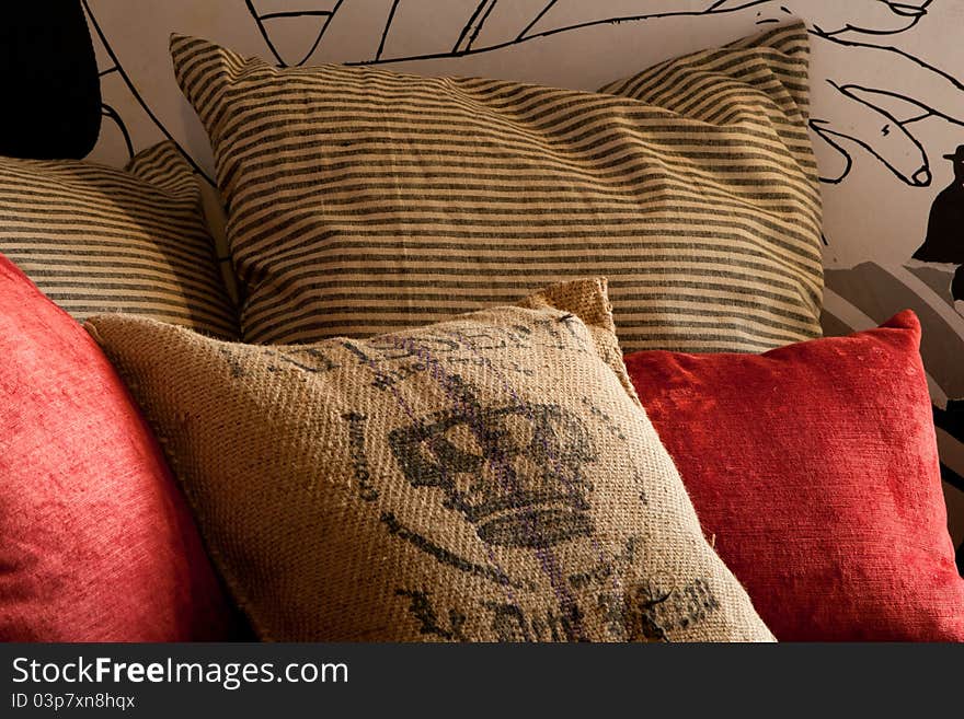 Red and sackcloth pillows closeup in grunge style decorated arrangement. Red and sackcloth pillows closeup in grunge style decorated arrangement