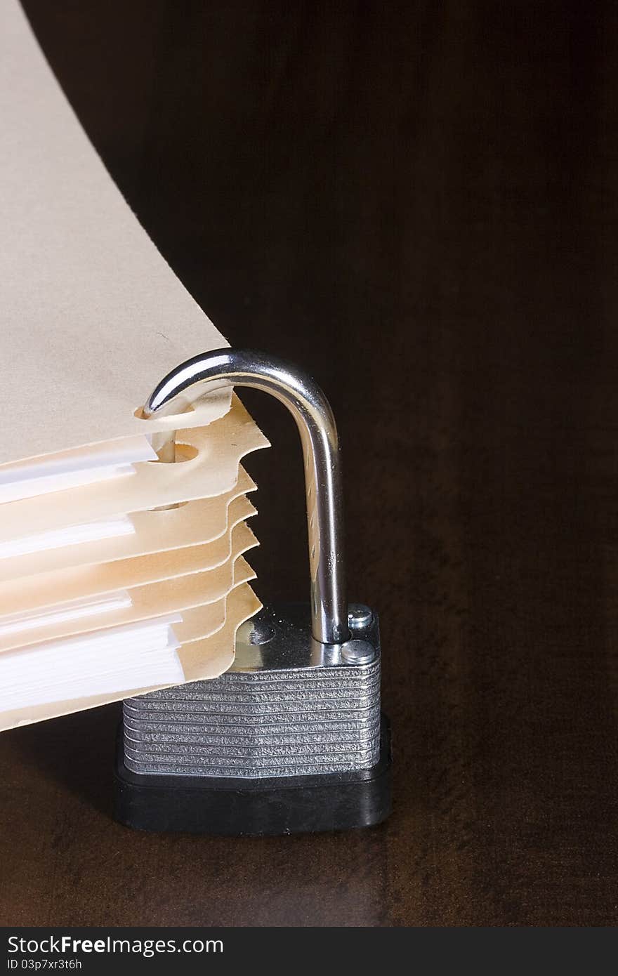 Stack of manila folders closed with a metal lock. Stack of manila folders closed with a metal lock.