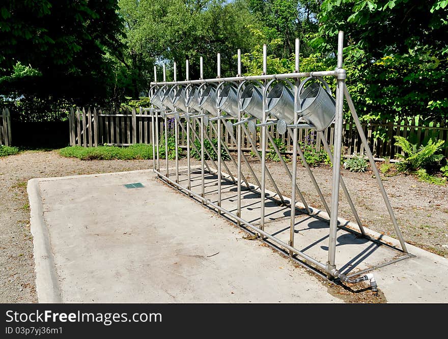 Row of watering cans in community garden