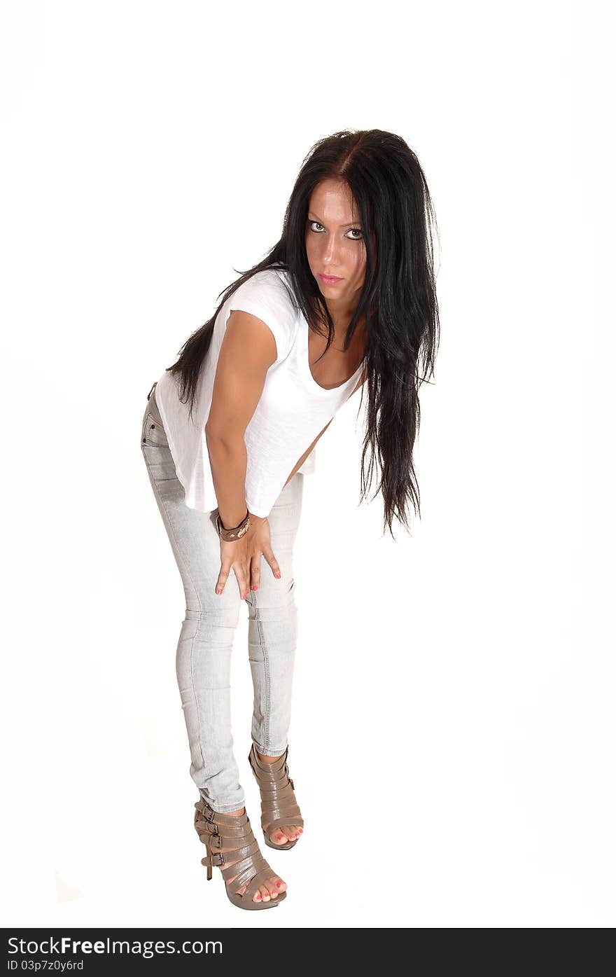 A pretty young woman with long black hair standing in the studio in light gray jeans, looking into the camera, for white background. A pretty young woman with long black hair standing in the studio in light gray jeans, looking into the camera, for white background.