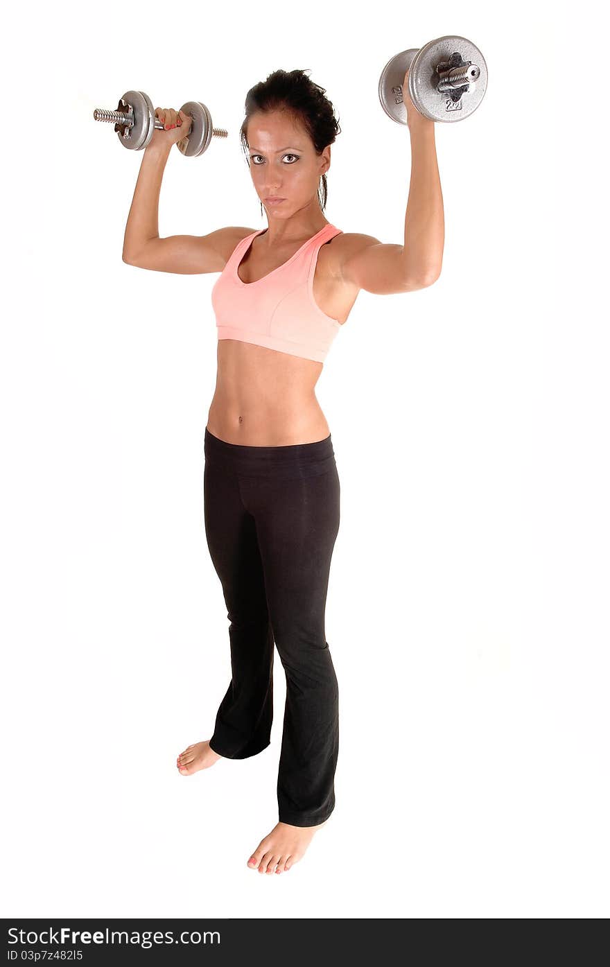 A pretty woman with dumbbells lifting, standing in the studio with bare feet, for white background. A pretty woman with dumbbells lifting, standing in the studio with bare feet, for white background.