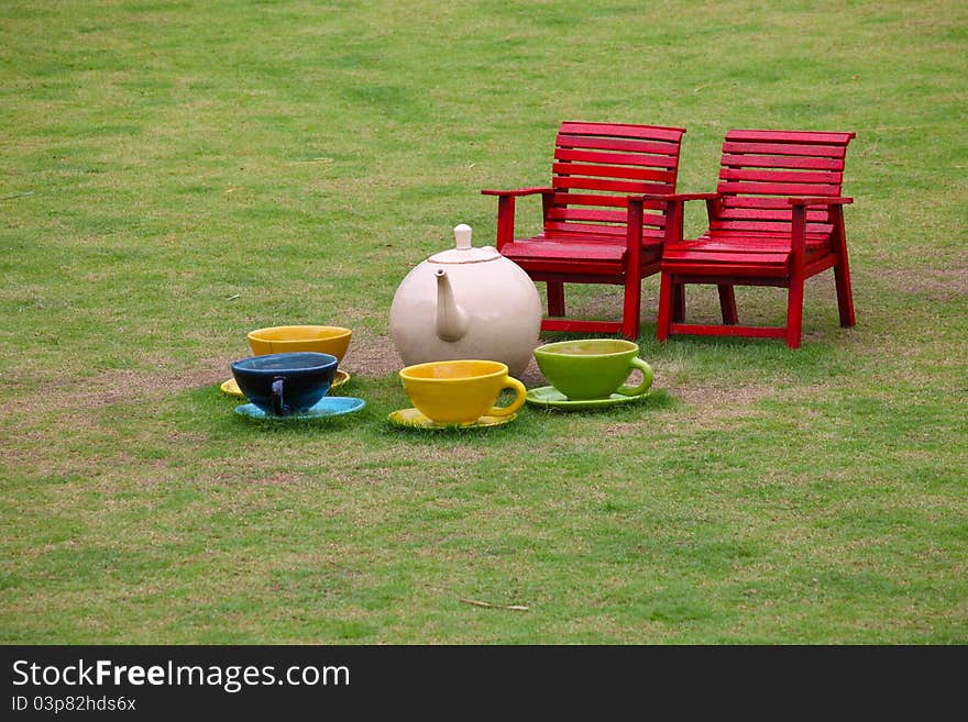 Red chairs and ceramic tea set in garden