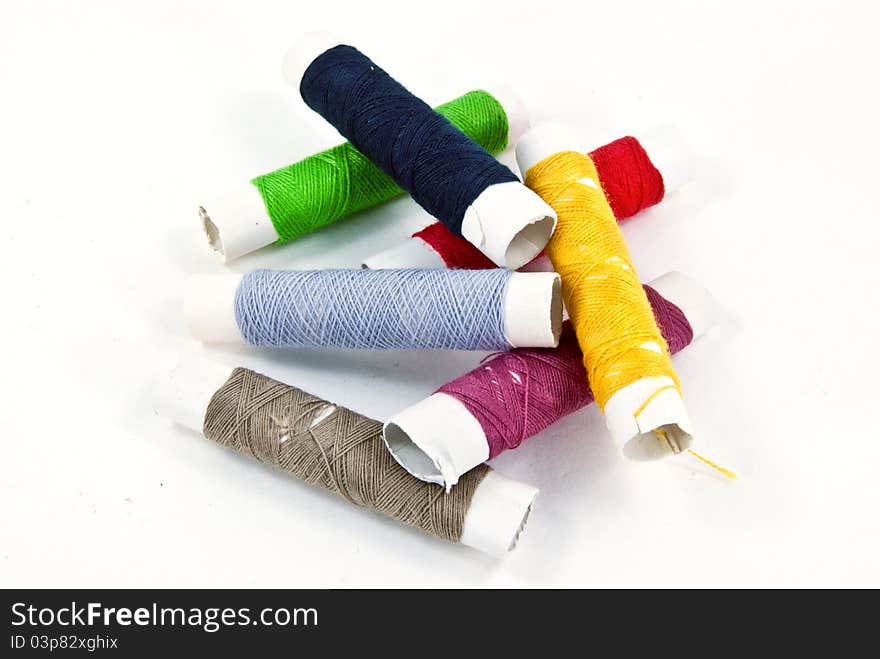 A mixture of colorful spools of thread put messily.