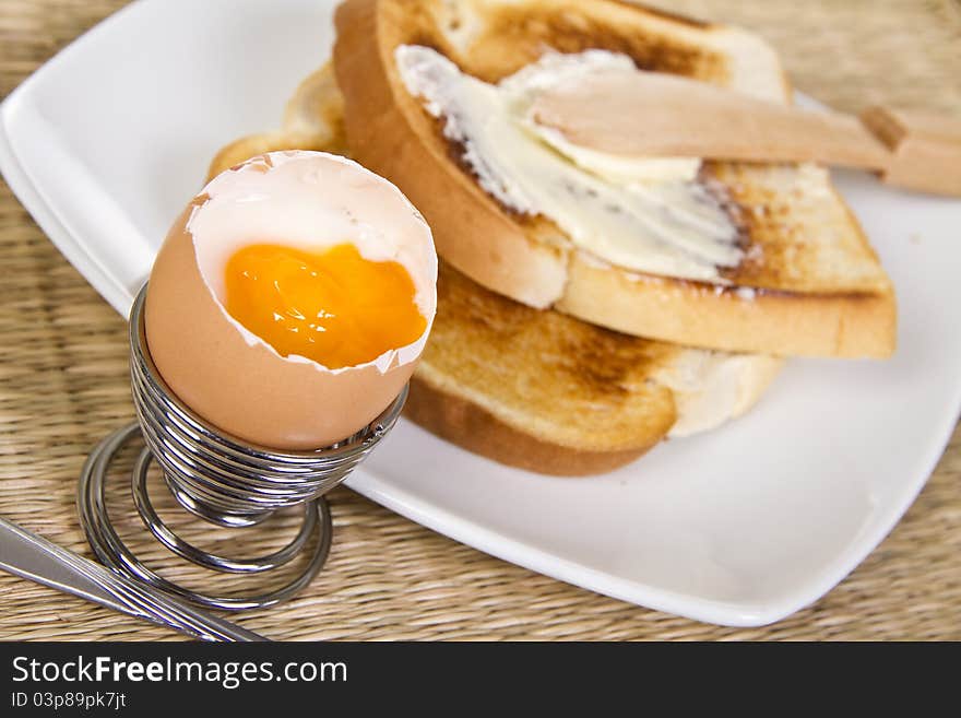 Soft boiled egg with crispy toasts on the plate. Soft boiled egg with crispy toasts on the plate