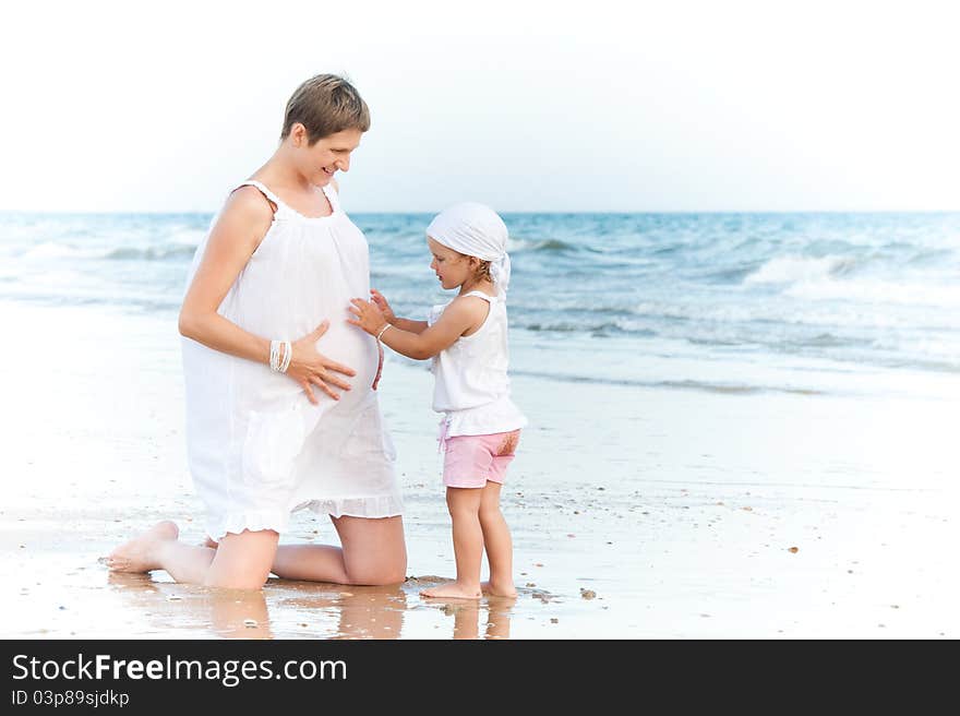 Little girl is touching pregnant belly