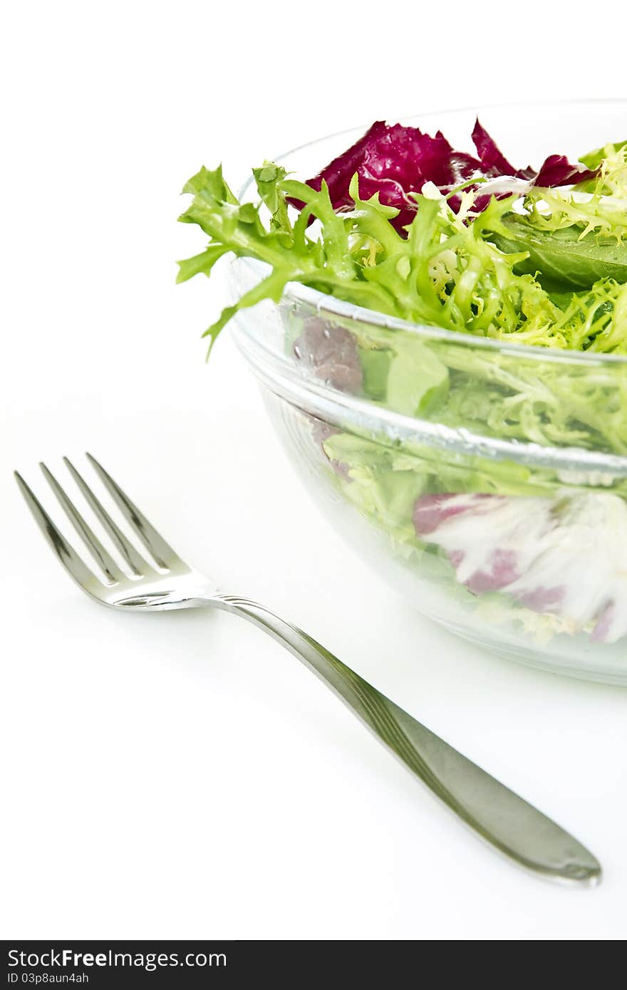 Bowl of fresh salad and fork - isolated