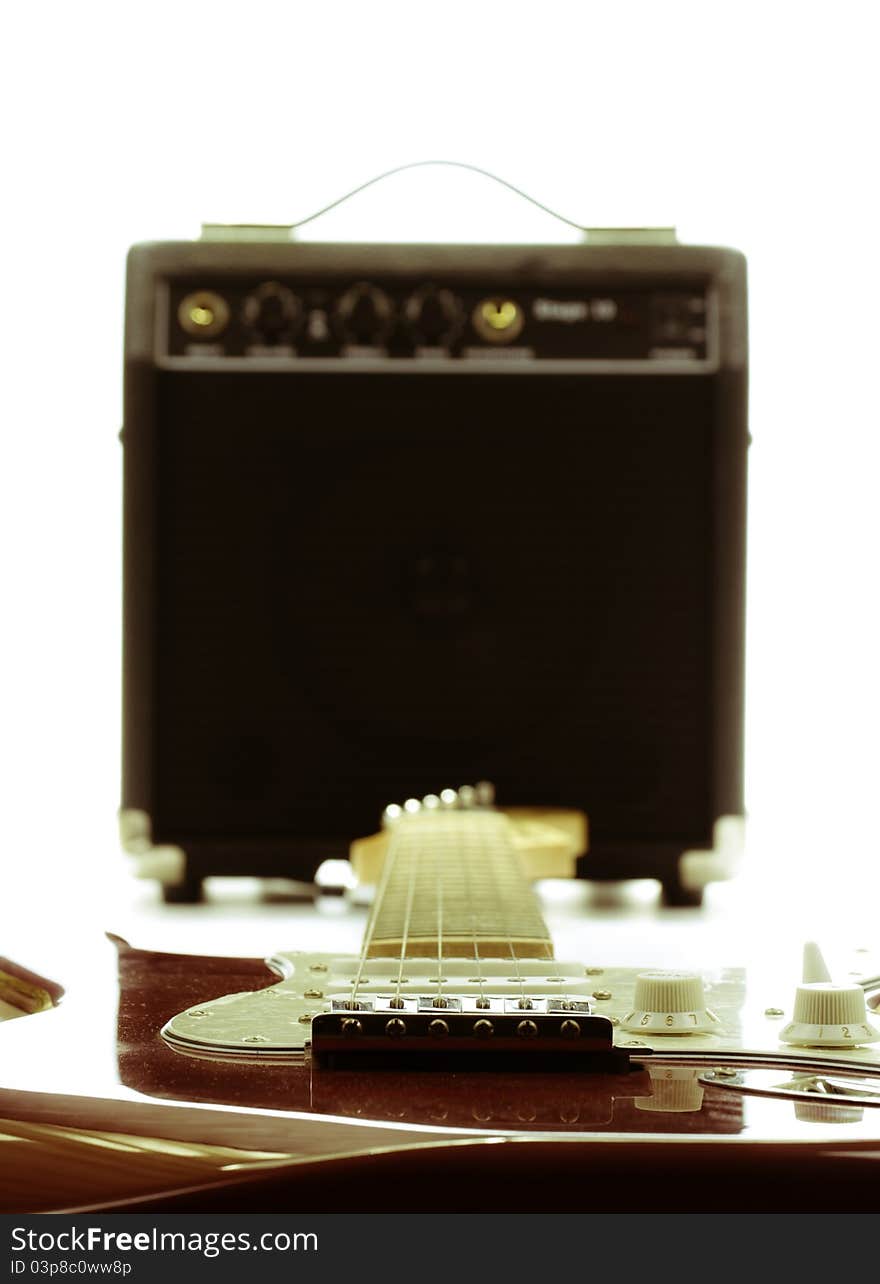 Electric guitar and amplifier isolated on the white background with retro look, focus point is on guitar. Electric guitar and amplifier isolated on the white background with retro look, focus point is on guitar