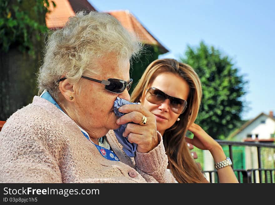 Portrait of grandmother and granddaughter taken in the exterior.