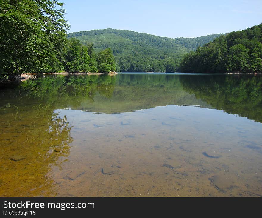 Calm nature lake in the middle of forest hills. Calm nature lake in the middle of forest hills