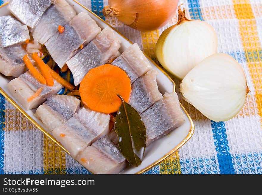 Salted herring in oil with onion on the plate