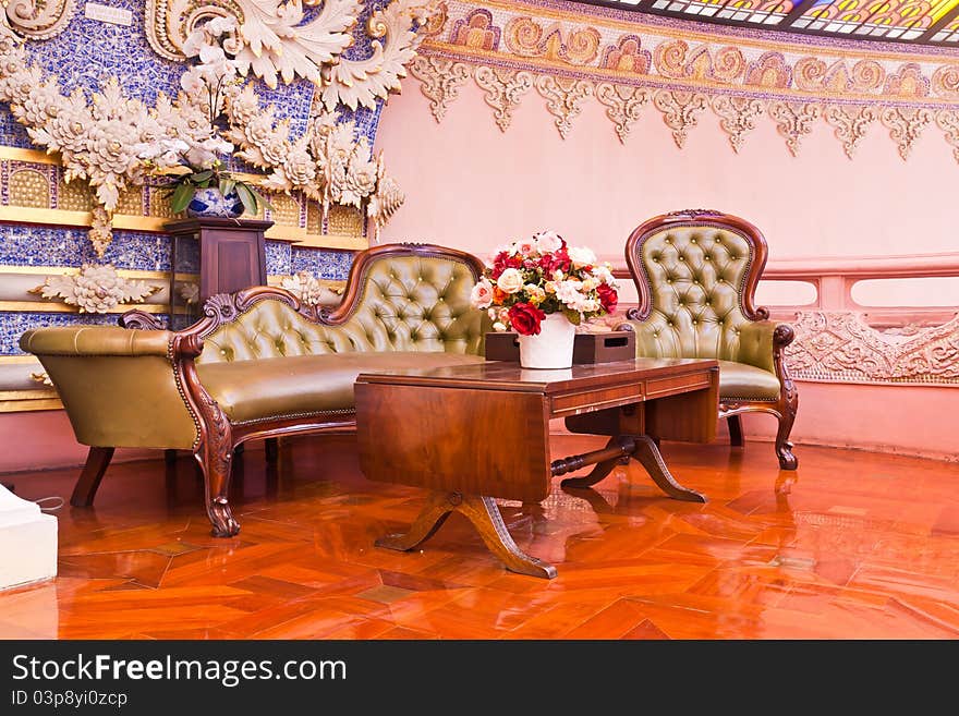 Green leather couch and wooden table