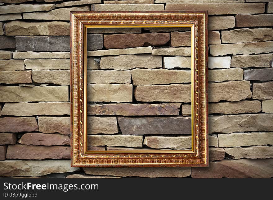 Golden frame on old brick wall