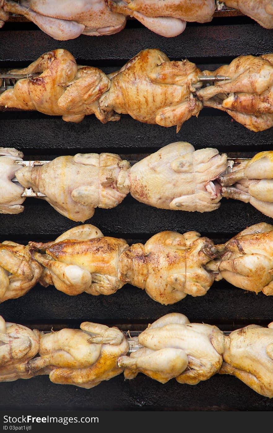 Chickens are spit roast in a French market. Chickens are spit roast in a French market