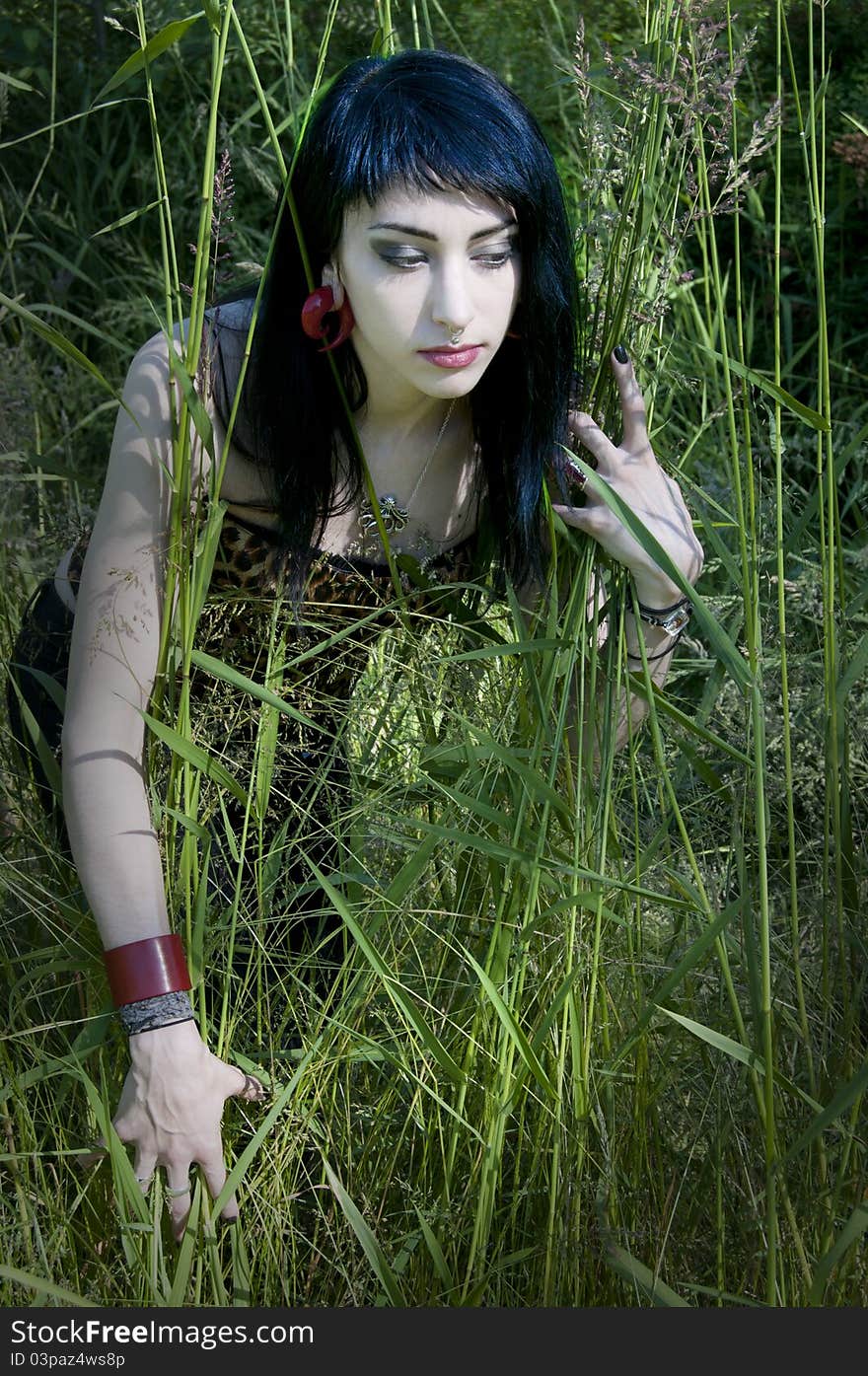 Gorgeous brunette model sitting in the green grass. Gorgeous brunette model sitting in the green grass