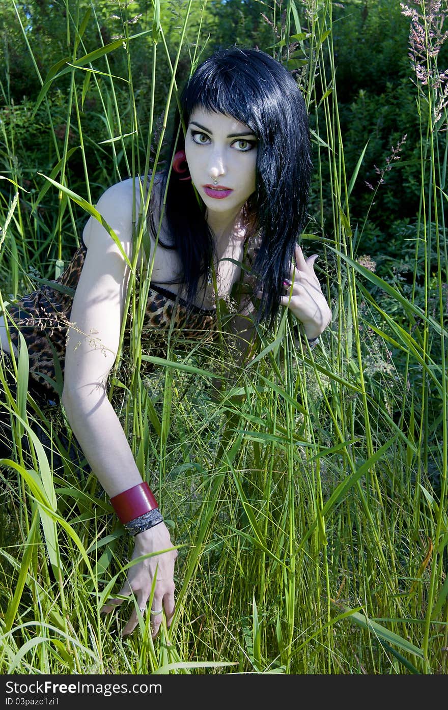 Gorgeous brunette model sitting in the green grass. Gorgeous brunette model sitting in the green grass