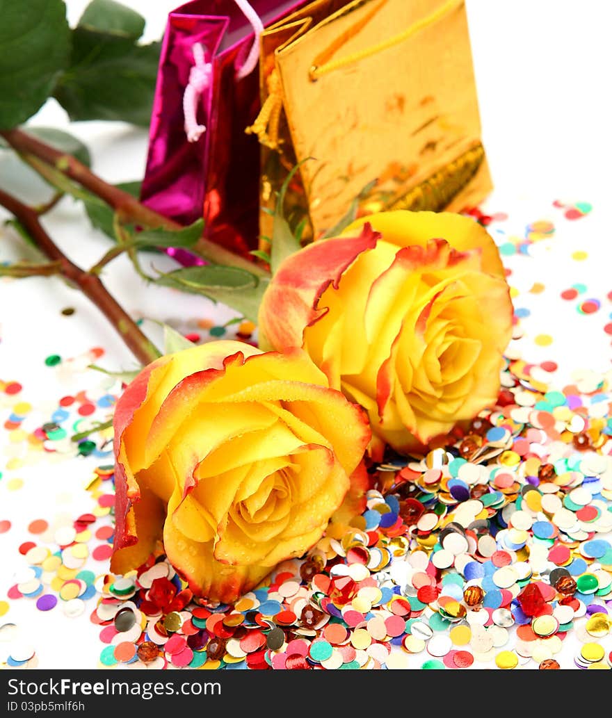 Yellow roses and confetti on a white background