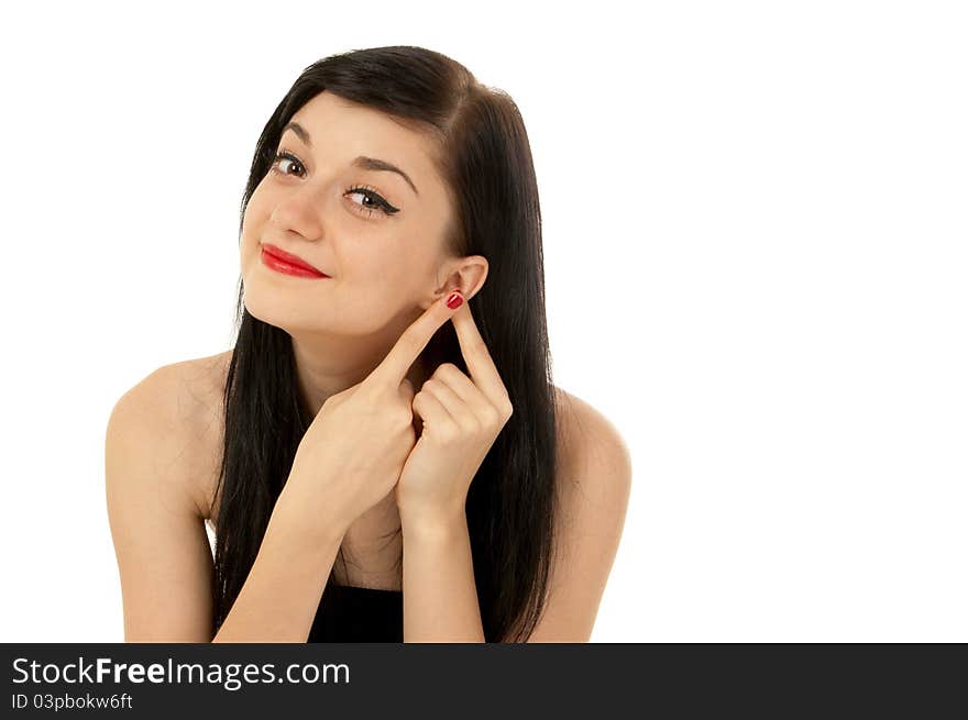 Beautiful brunette girl wearing a black dress putting her fingers to her ear on white background