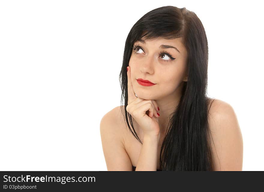 Beautiful brunette girl putting her hand to the face  and  looking up thoughtfully on white background