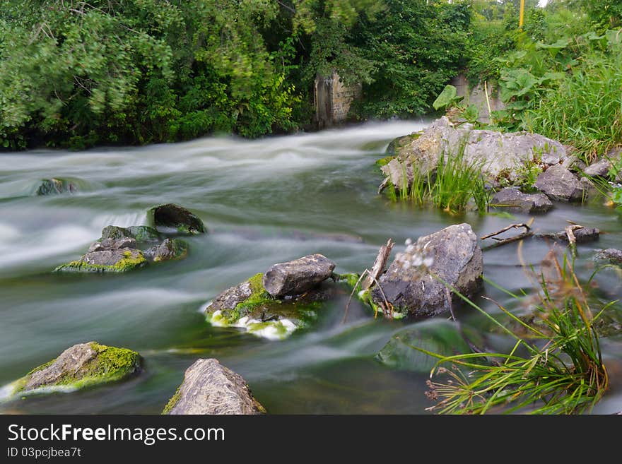 Flow water in river. Speed, summer, stone.