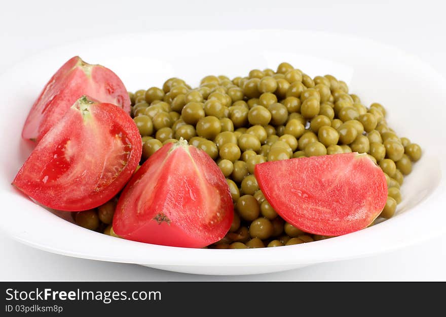 Color photograph of green peas and tomato