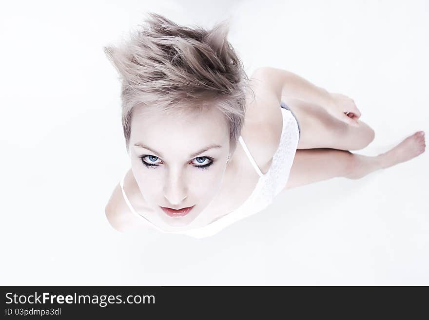 Studio portrait of young beautiful woman with creative haircut looking up