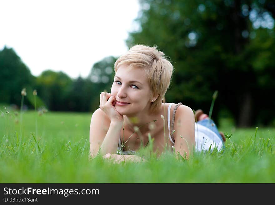 Beautiful healthy Young Woman relaxing on the green grass. Beautiful healthy Young Woman relaxing on the green grass