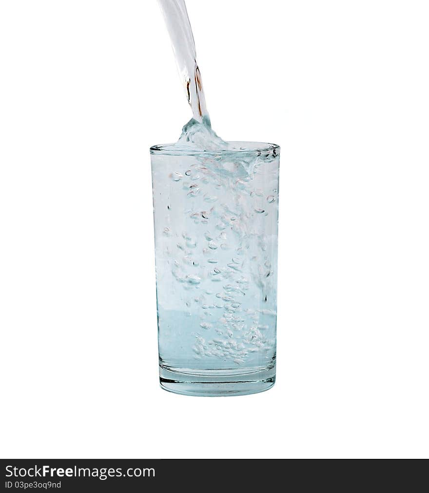 Pouring water in a glass isolated against white background