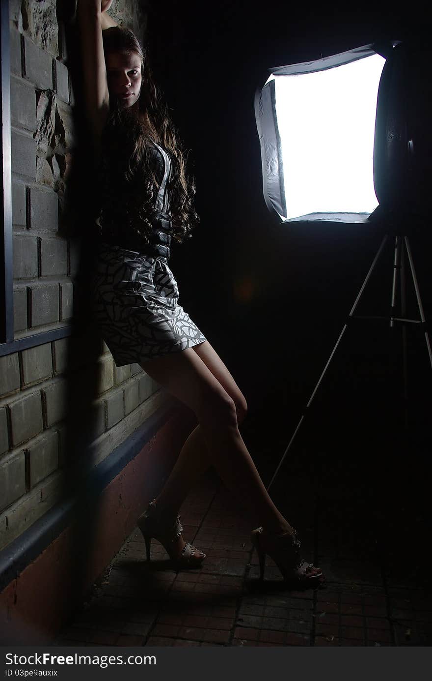 Girl leaning against a wall and a softbox