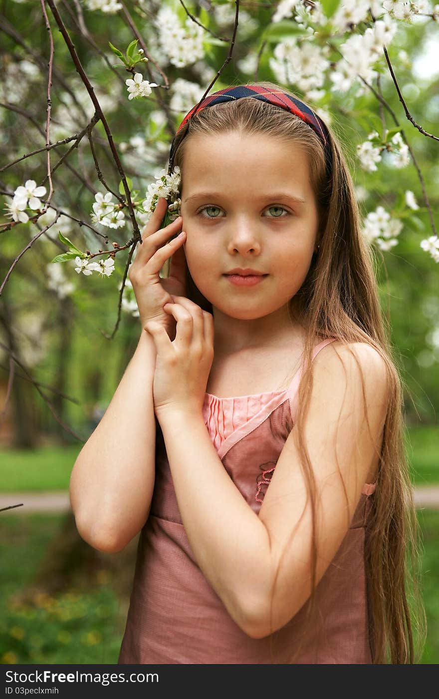 The little girl in a cherry garden