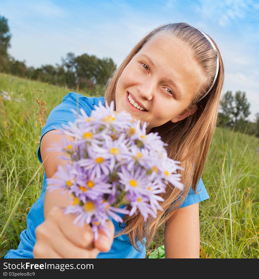 The girl camomile, sitting on a green grass. The girl camomile, sitting on a green grass