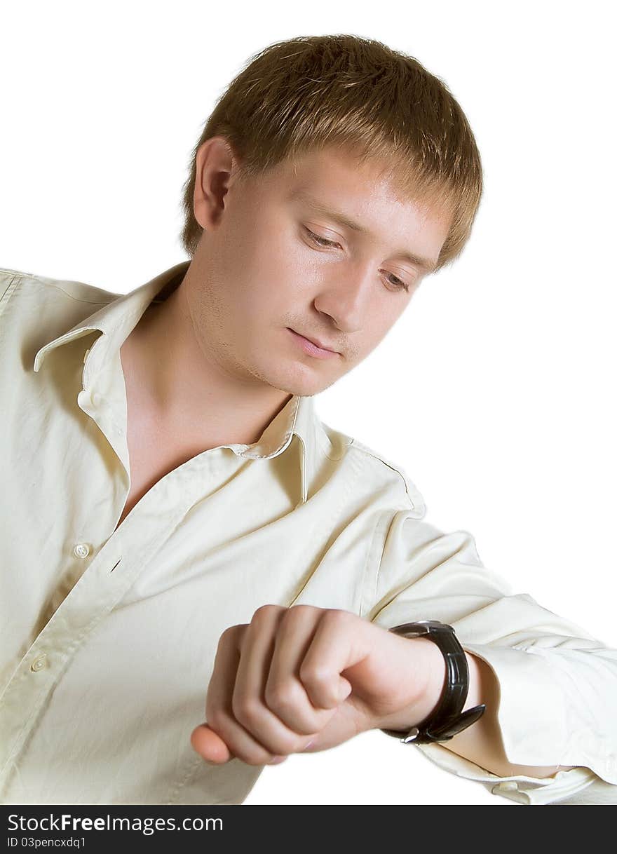 The young man in a light shirt looks at a watch. The young man in a light shirt looks at a watch