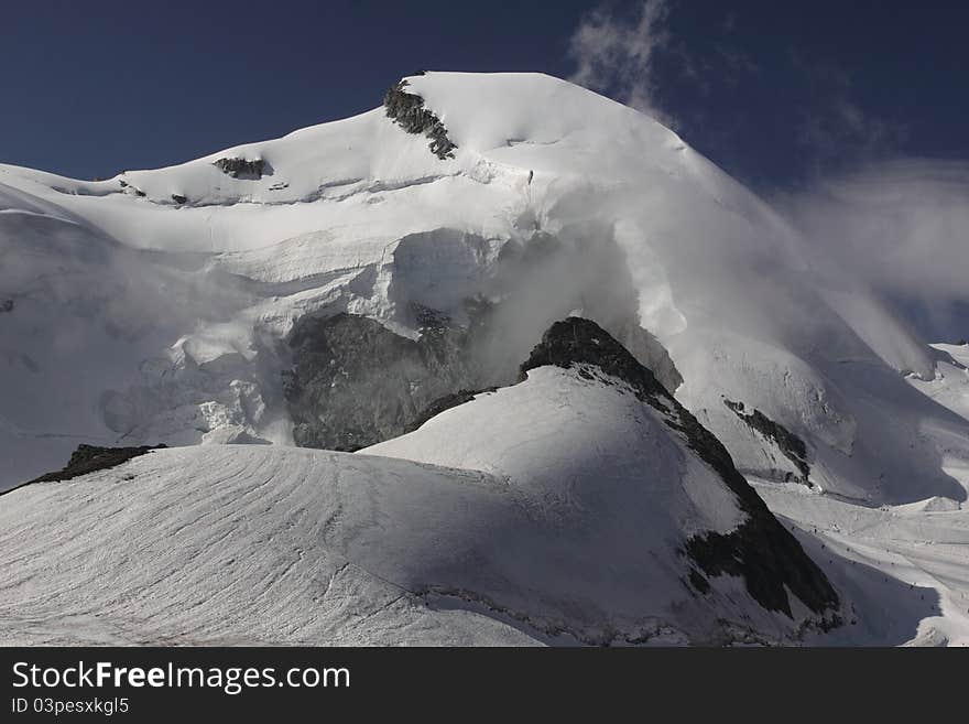 The allalinhorn capped with the mass of snow in Pennine Alps, Switzerland. The allalinhorn capped with the mass of snow in Pennine Alps, Switzerland.