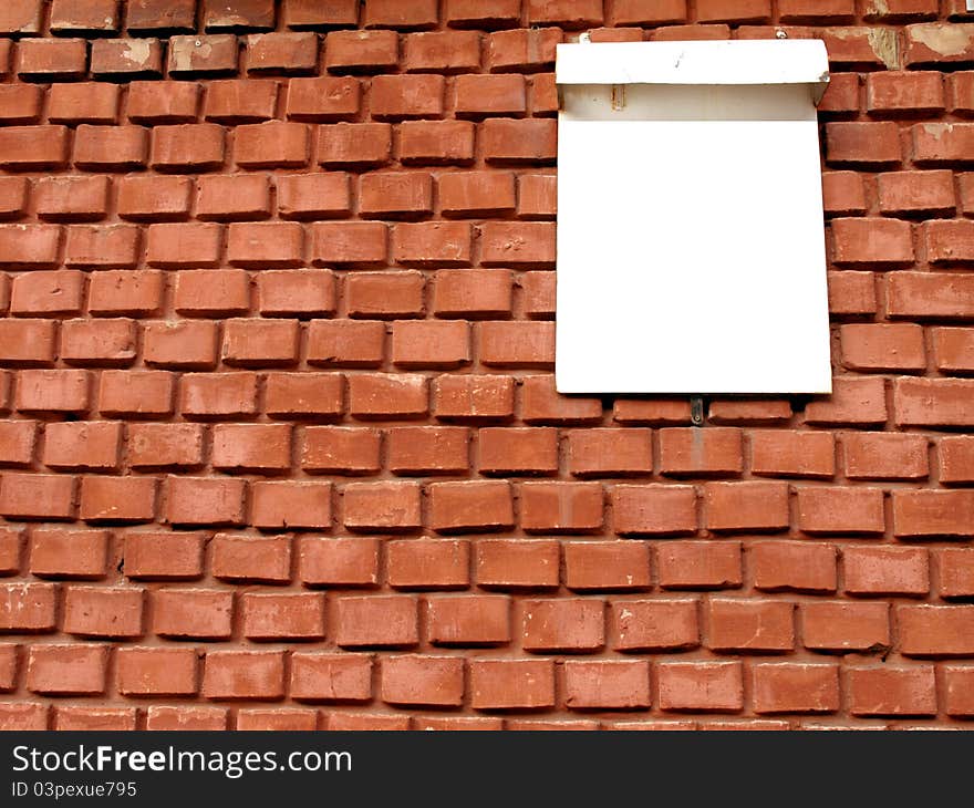 Red brick walls with a white sign for the house number. Red brick walls with a white sign for the house number