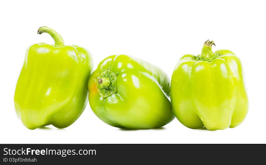 Three sweet green peppers over white background