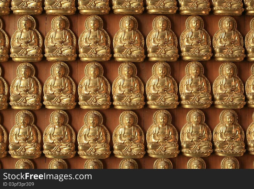 Many Gold Buddha sculptures on the wall