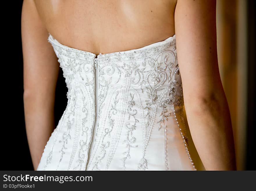 A close up of a caucasian bride's wedding dress at the back. A close up of a caucasian bride's wedding dress at the back