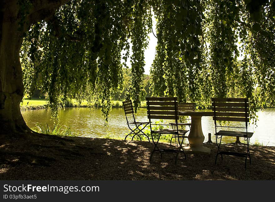 Table and chairs next to a pond