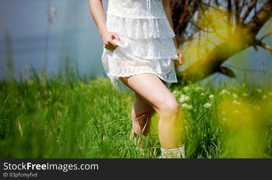 Girl in white dress walking in the green field