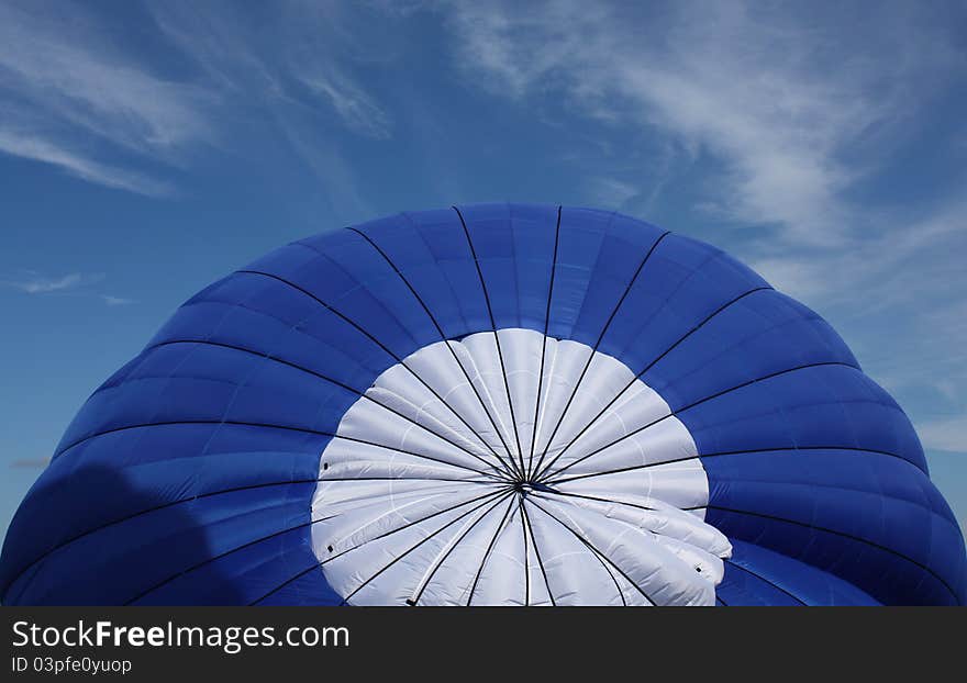 Decaying blue gondola on the ground against the blue sky