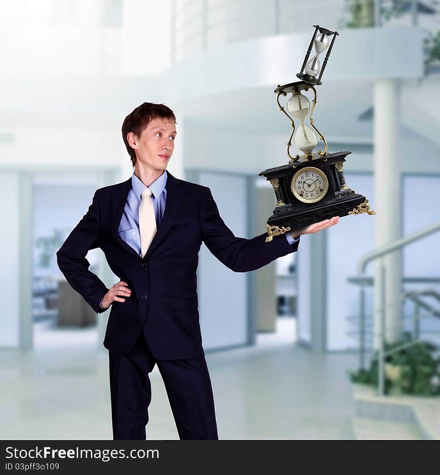 Businessman In Office Holding Clock Pyramid