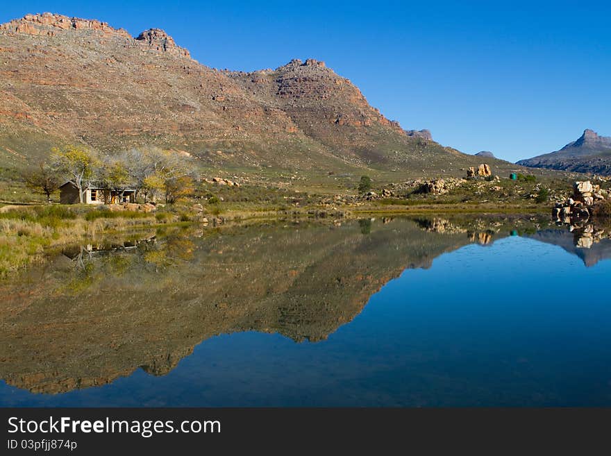 A small holiday home next to a lake with stunning reflextion in the water. A small holiday home next to a lake with stunning reflextion in the water