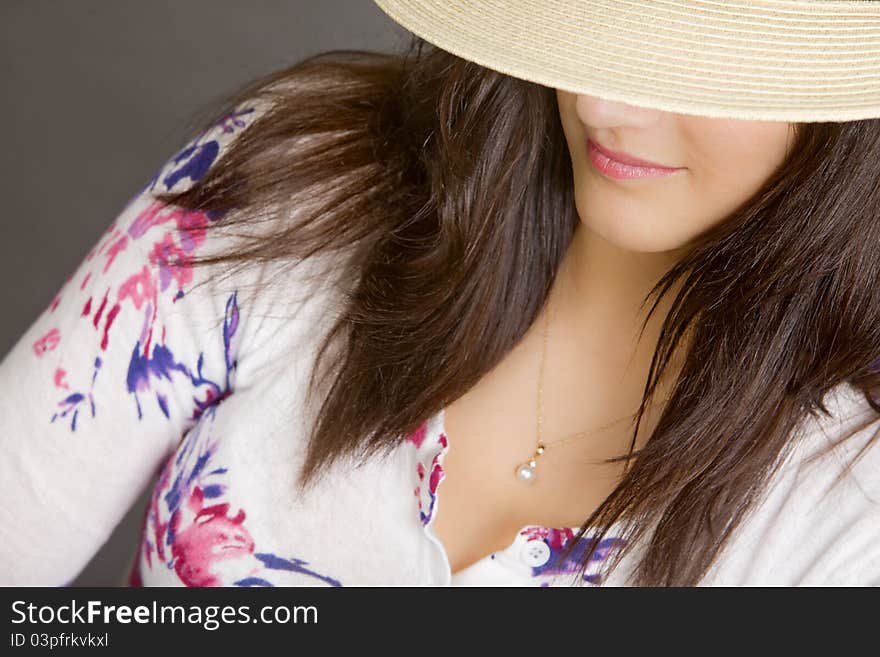 An attractive young woman wearing a white hat with a black band. Focus on her lips. An attractive young woman wearing a white hat with a black band. Focus on her lips.