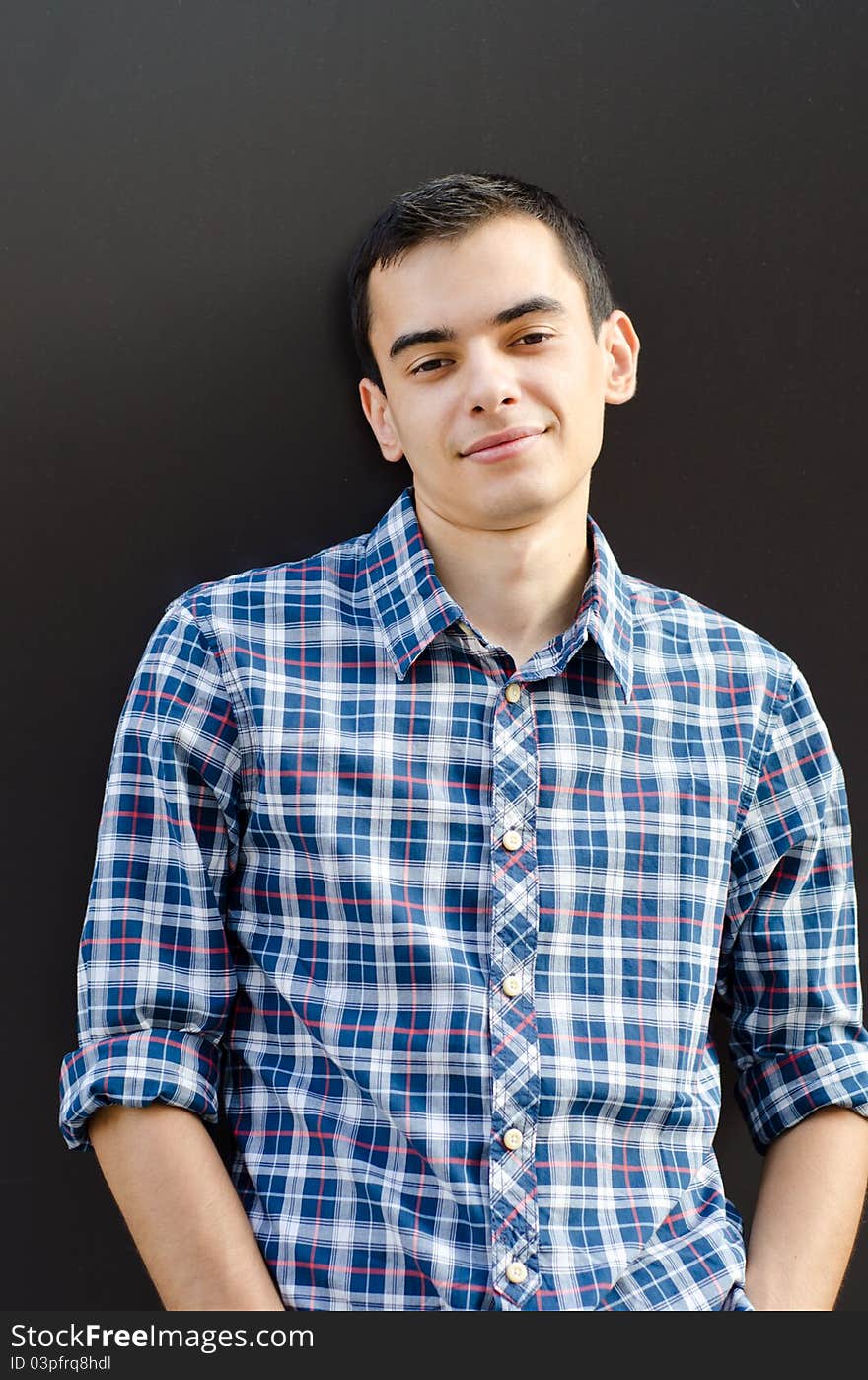 Portrait of handsome young man leaning casual on wall outside. Portrait of handsome young man leaning casual on wall outside