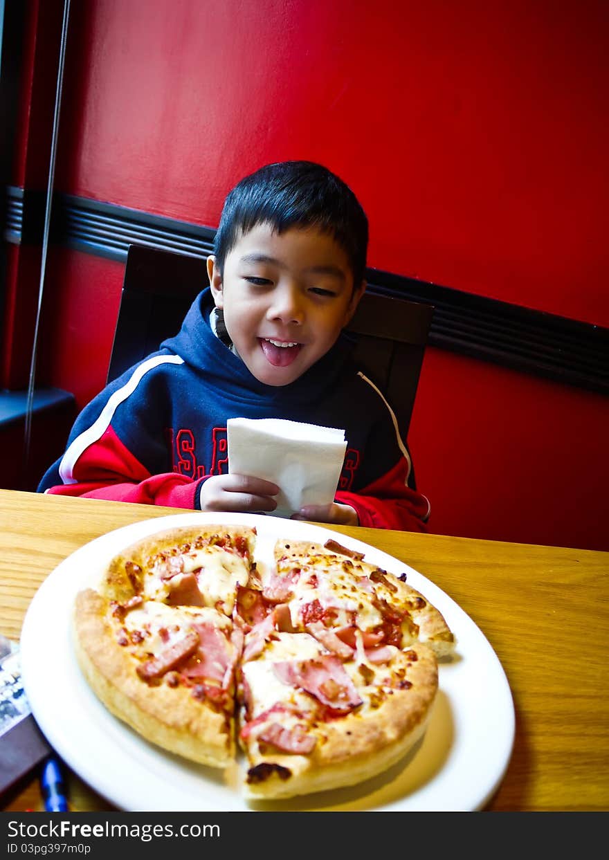 Asian Boy ready to eat a pizza with Happy and Enjoy. Asian Boy ready to eat a pizza with Happy and Enjoy