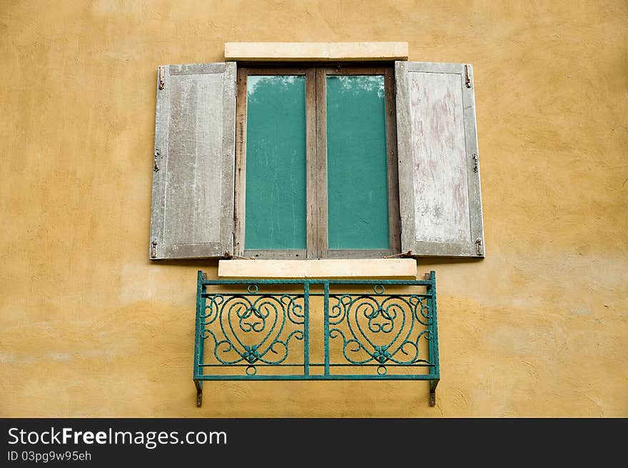 Old wooden window on yellow wall