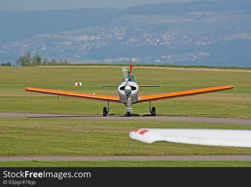 Small ariplane on the ground near hangar