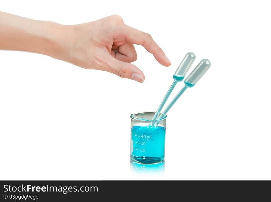 Pipette in glass beaker with blue liquid in science lab
