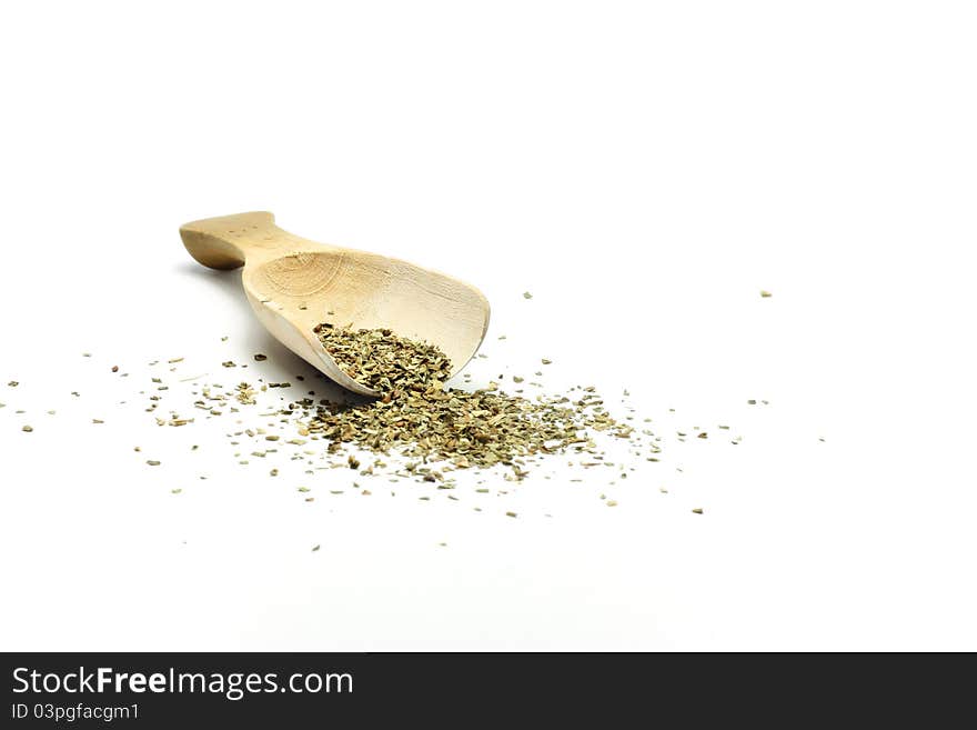 A wooden spoon with basil is isolated